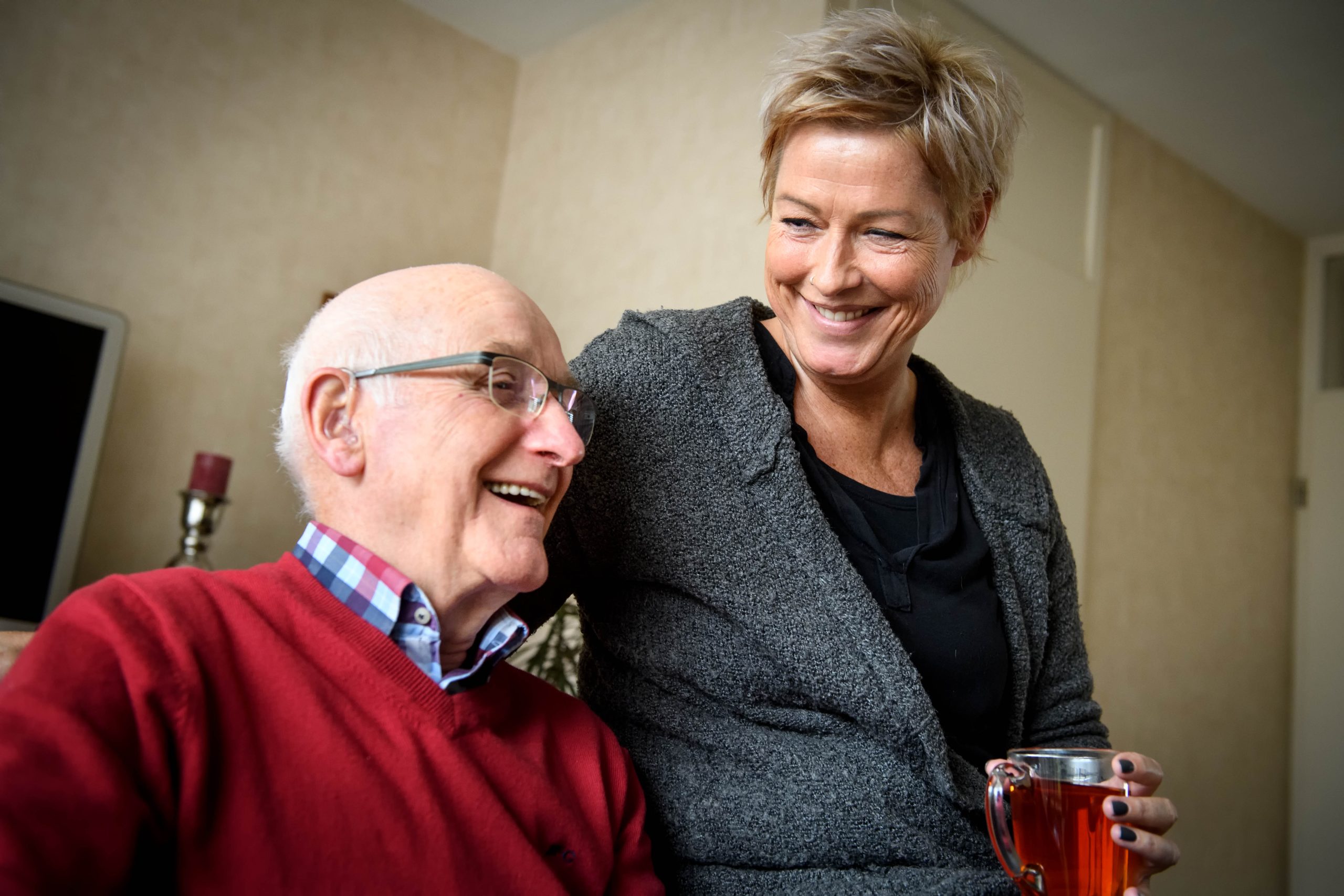 dochter drinkt met oudere vader een kopje thee
