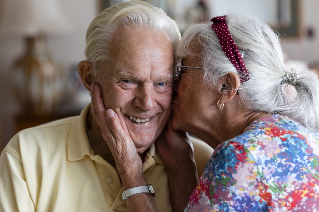 oudere vrouw geeft oudere man kus op de wang