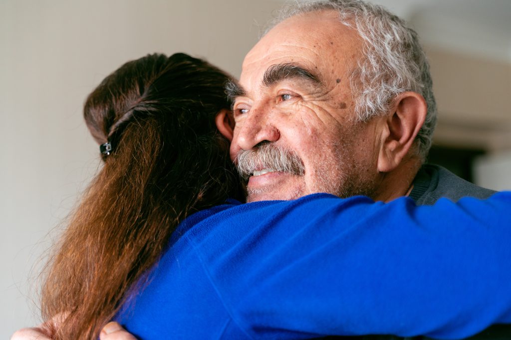 vrouw geeft oudere man een knuffel
