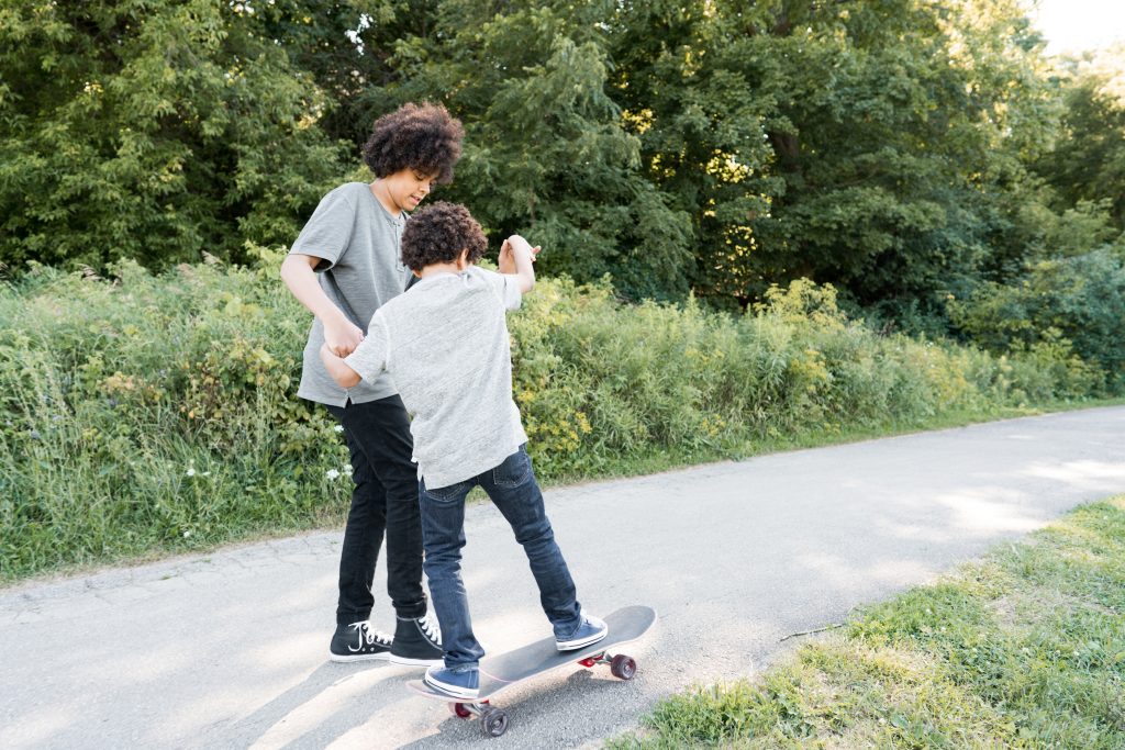 broer houdt kleinere broer vast op skateboard